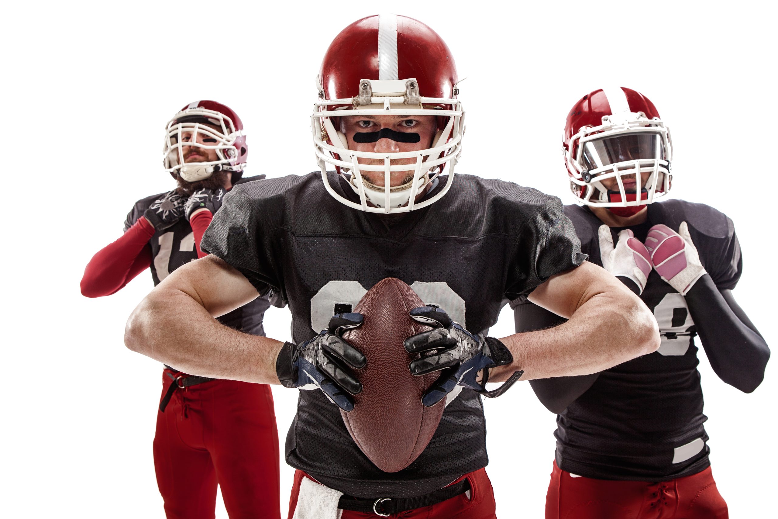 The three caucasian fitness men as american football players posing with a ball